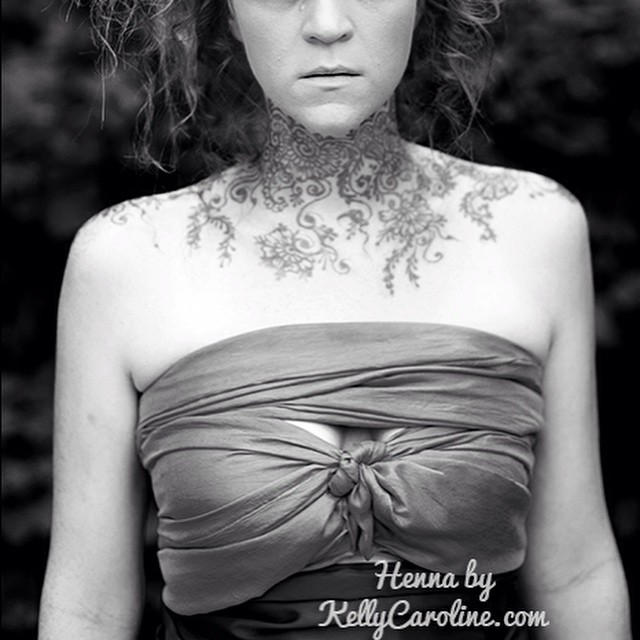 Viney and floral Henna tattoos on the neck and collar bone.